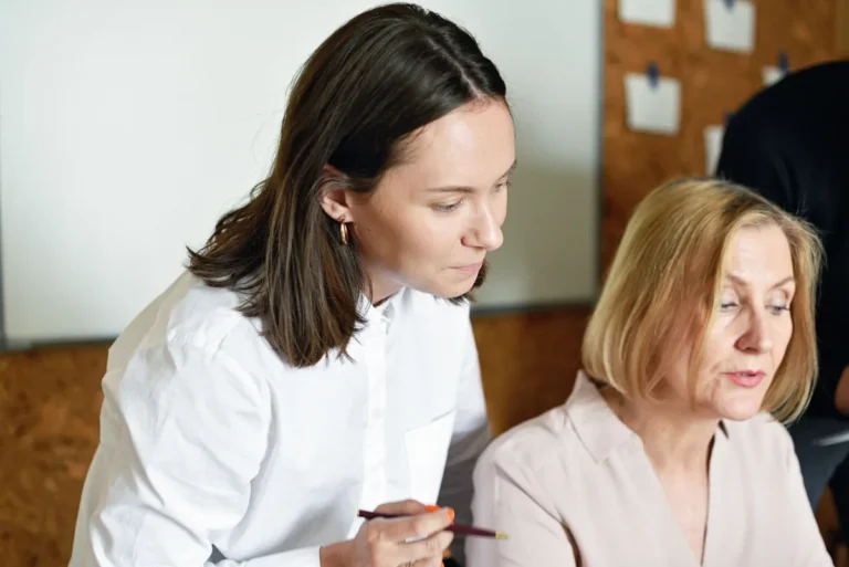 Zwei Kolleginnen besprechen gemeinsam Unterlagen am Arbeitsplatz
